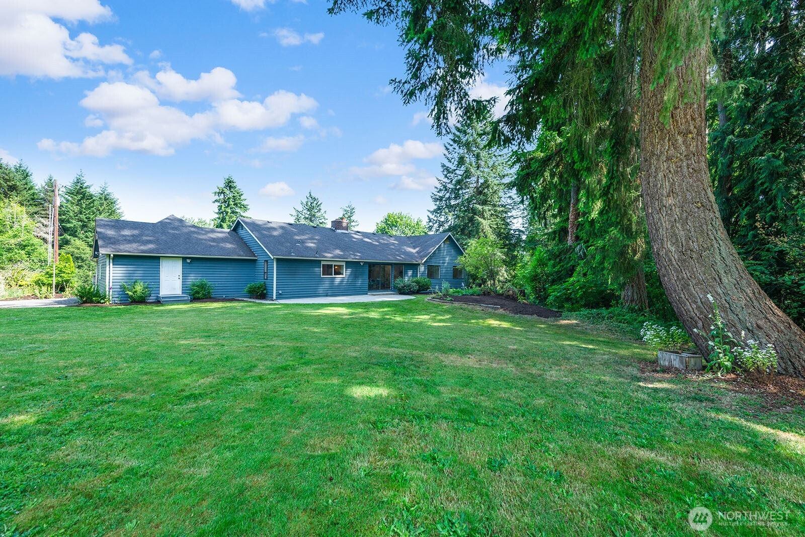 Back yard looking toward the house. Abundant grassy area for lawn games and gatherings.