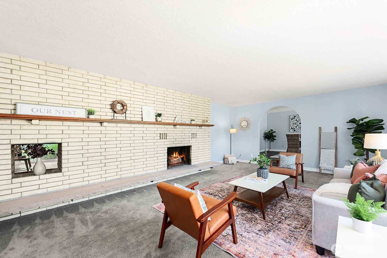 Formal living room with an extraordinary brick wall and mantel. Woodburning fireplace. Opening on the left of the brick wall can be used for wood storage or art...