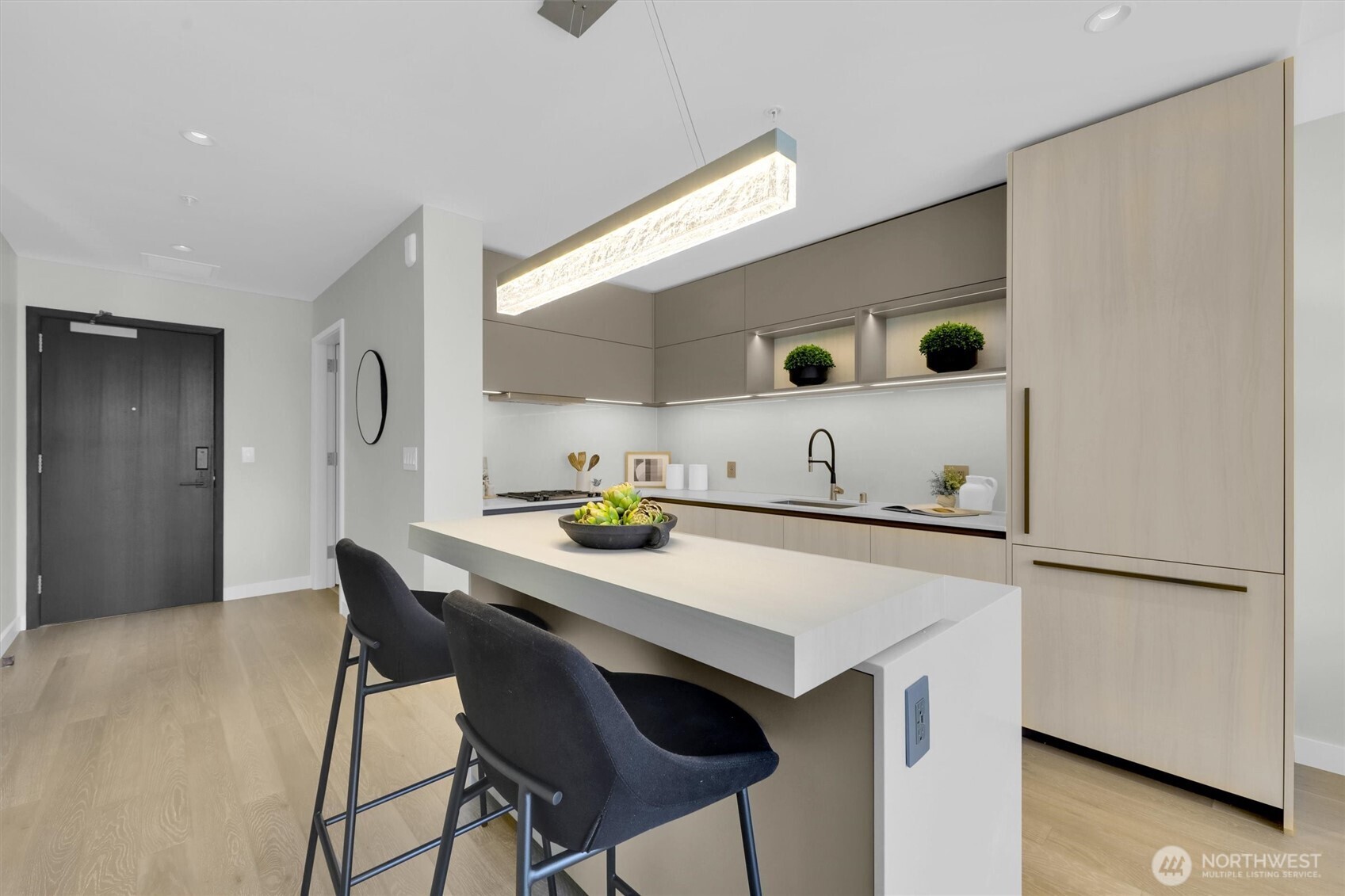 Beautiful Kitchen with 2 tier island counter and custom installed lighting above, built in fridge and cabinets
