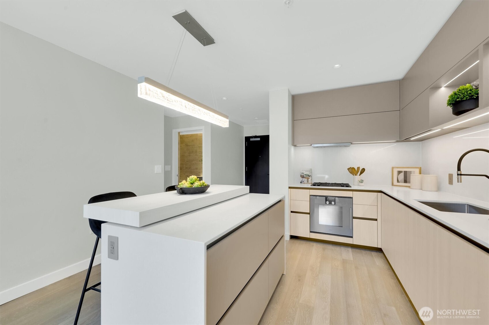 Kitchen with 2 tier island counter and custom installed lighting above