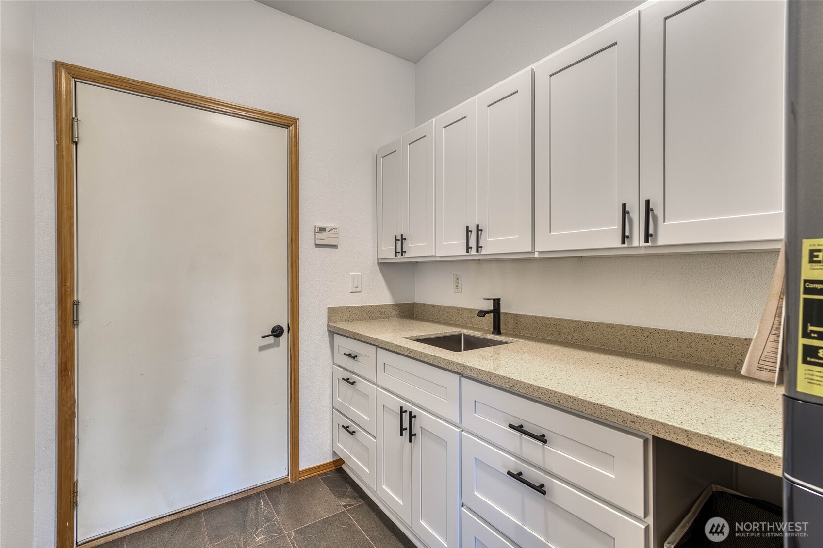 Newly remodeld utility room, lots of new cabinets, counter tops, sink and tile flooring.