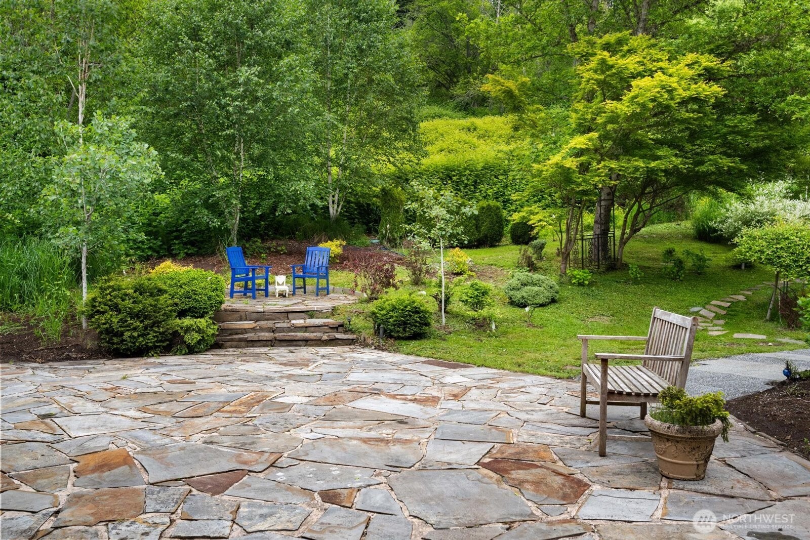 Wow! This backyard is incredible - including pond, mature specialty plants and charming features throughout