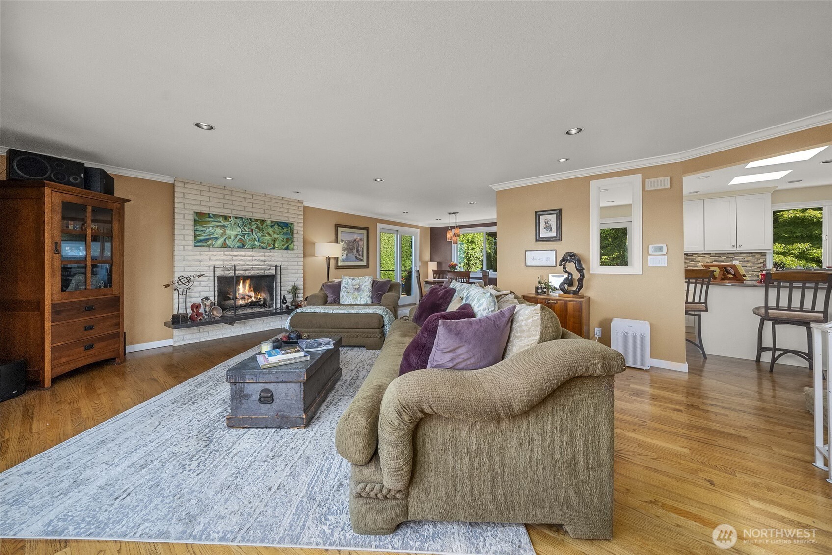 The designer earth tones and warm-toned hardwood flooring create a very comfortable atmosphere in this spacious living room. The Brick/Gas-Log Fireplace, Crown Molding and Recessed Lighting add to its elegance and charm.