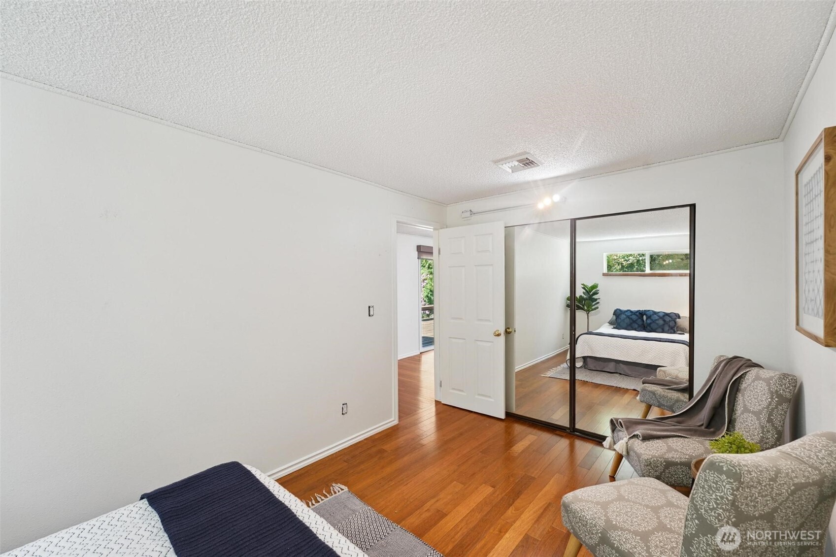 The main floor bedroom is fresh, bright, and airy