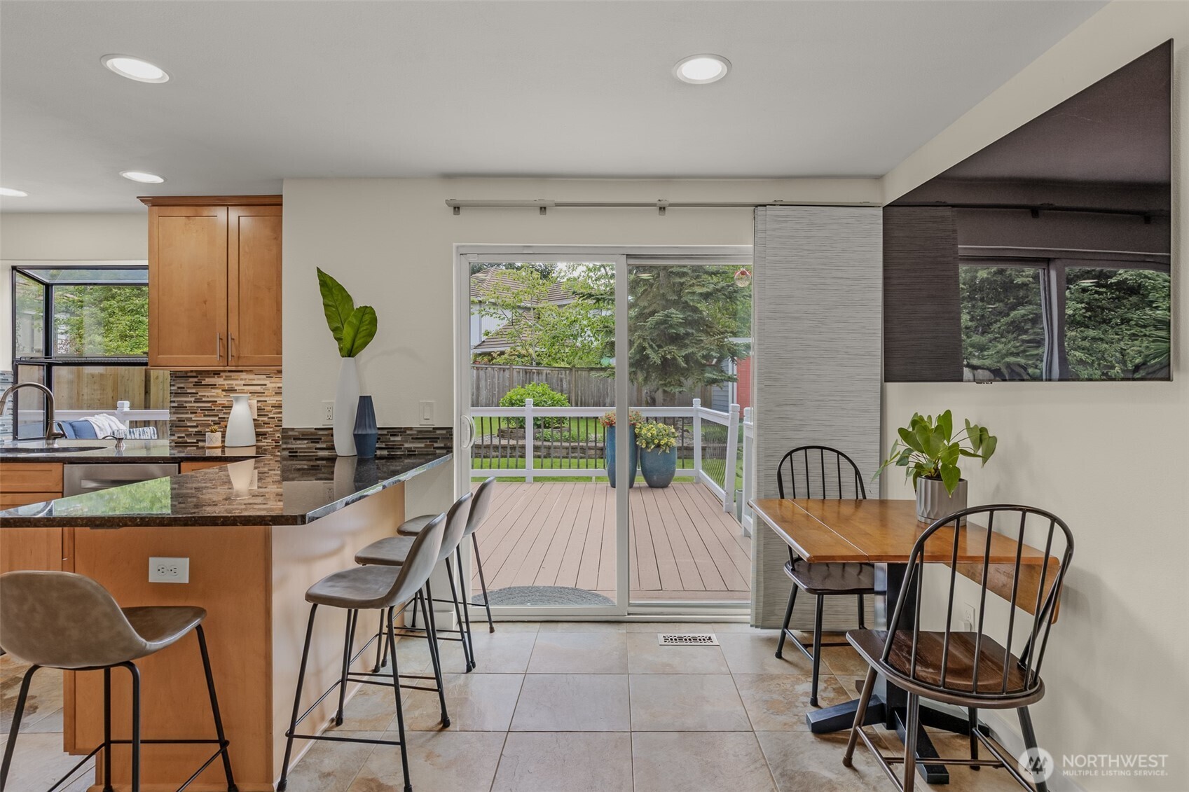 Eat-in kitchen with space for counter height stools and small table with sliding door access to backyard.