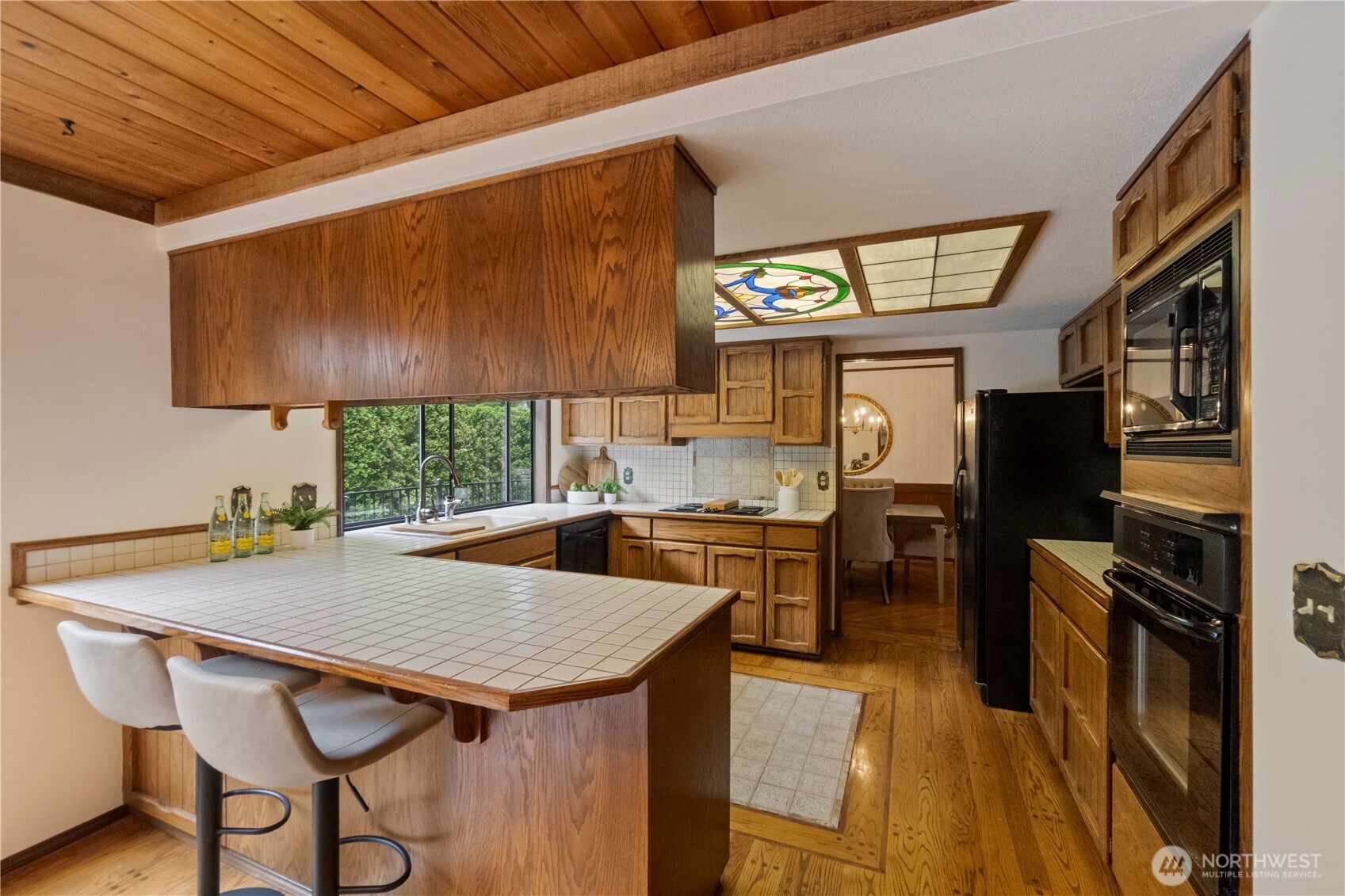 Kitchen has a breakfast bar and opens to a casual dining area (not pictured here). Through the far doorway is the formal living room.
