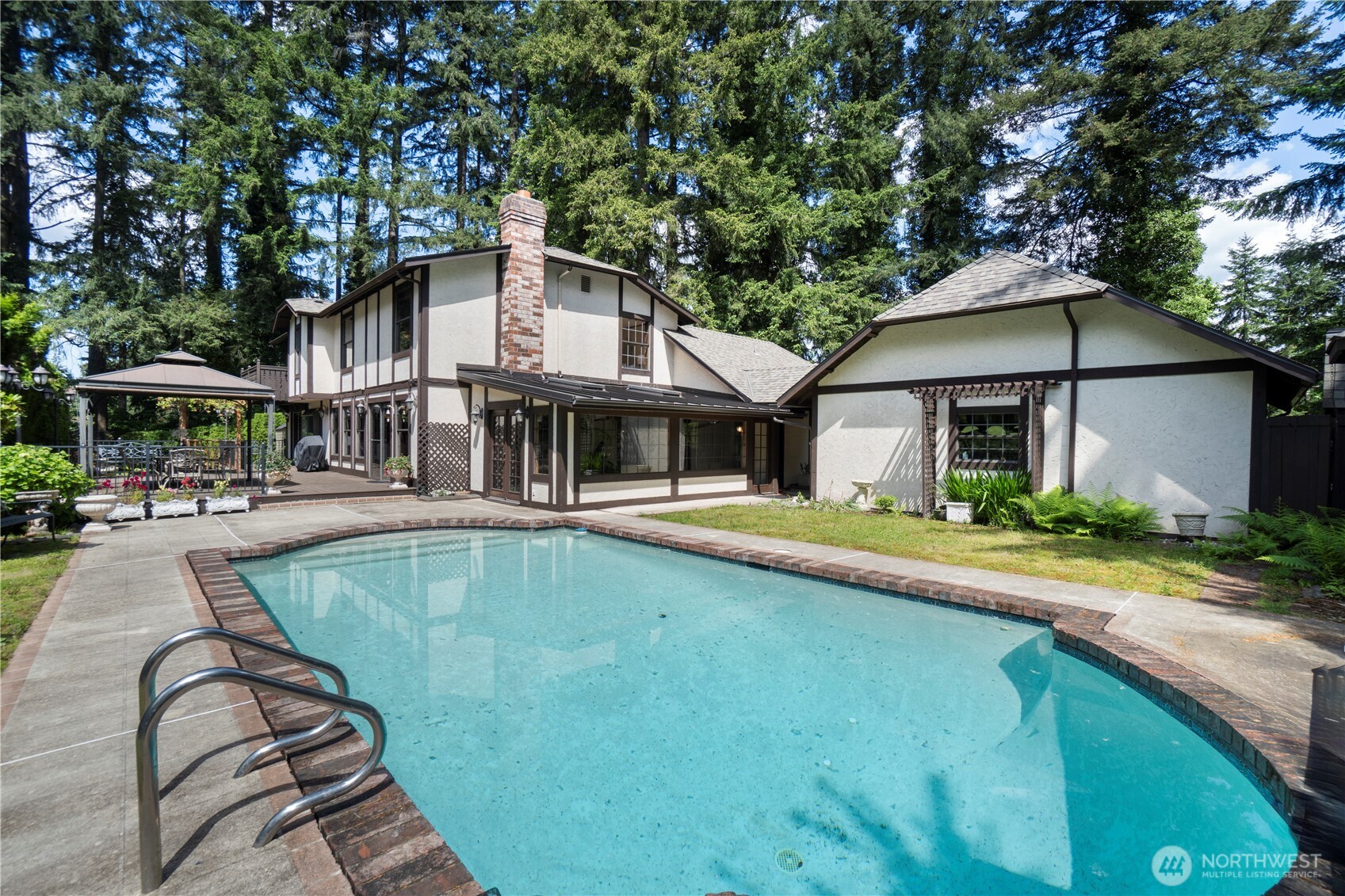 Great view of the pool looking to the house, garage and deck.