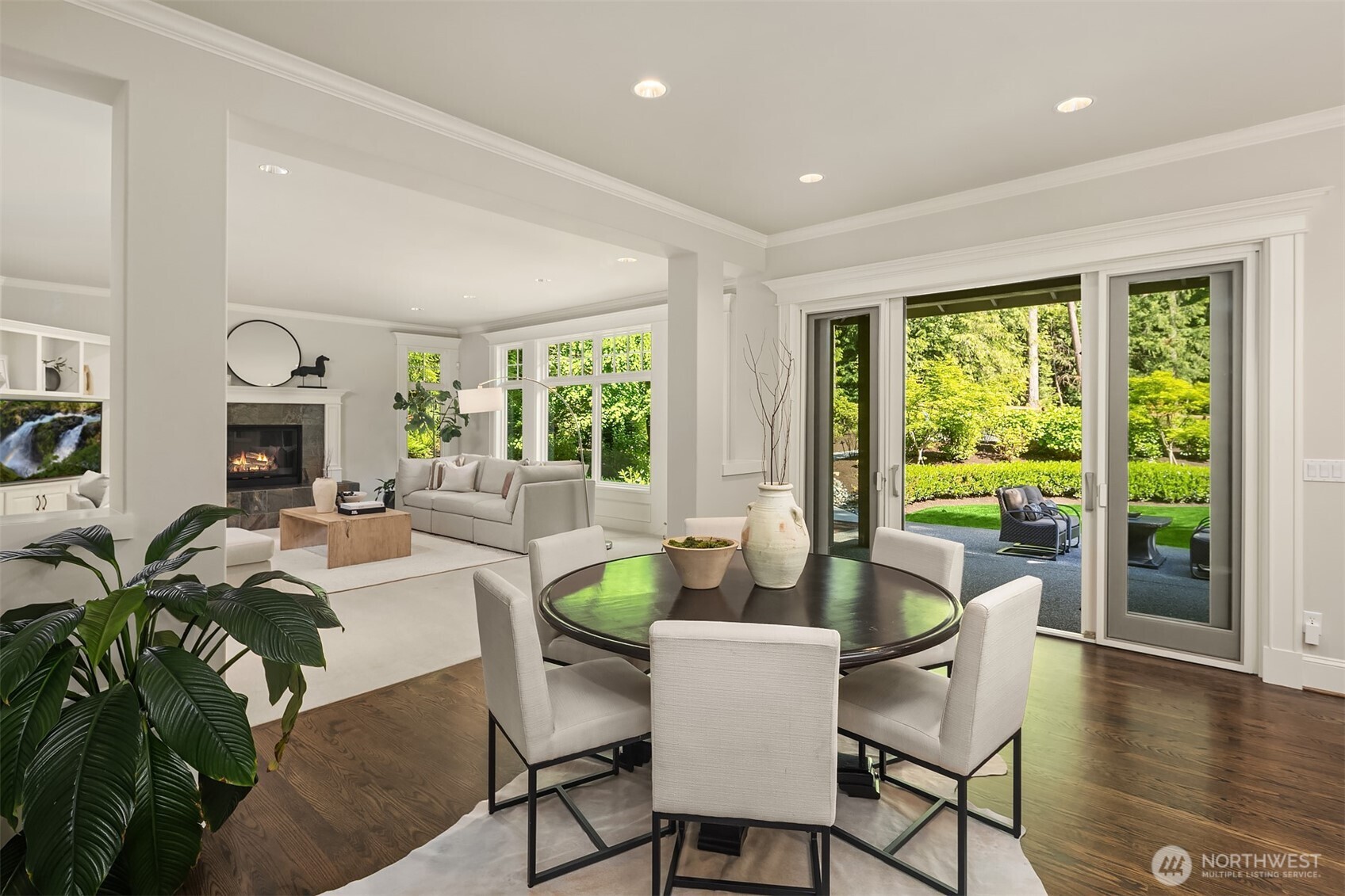 Curved staircase and views of eating area and family room and outdoor entertainment spaces.