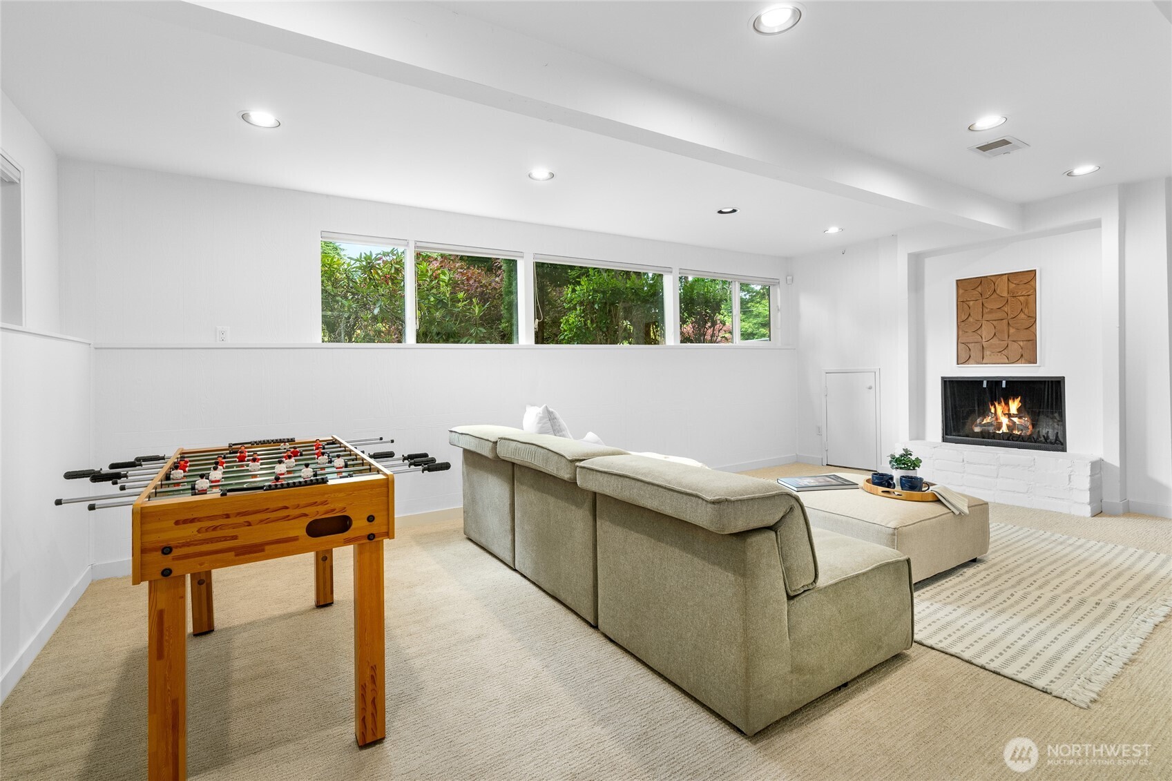 Large rec room with fireplace and space to play, relax, and enjoy movie nights.