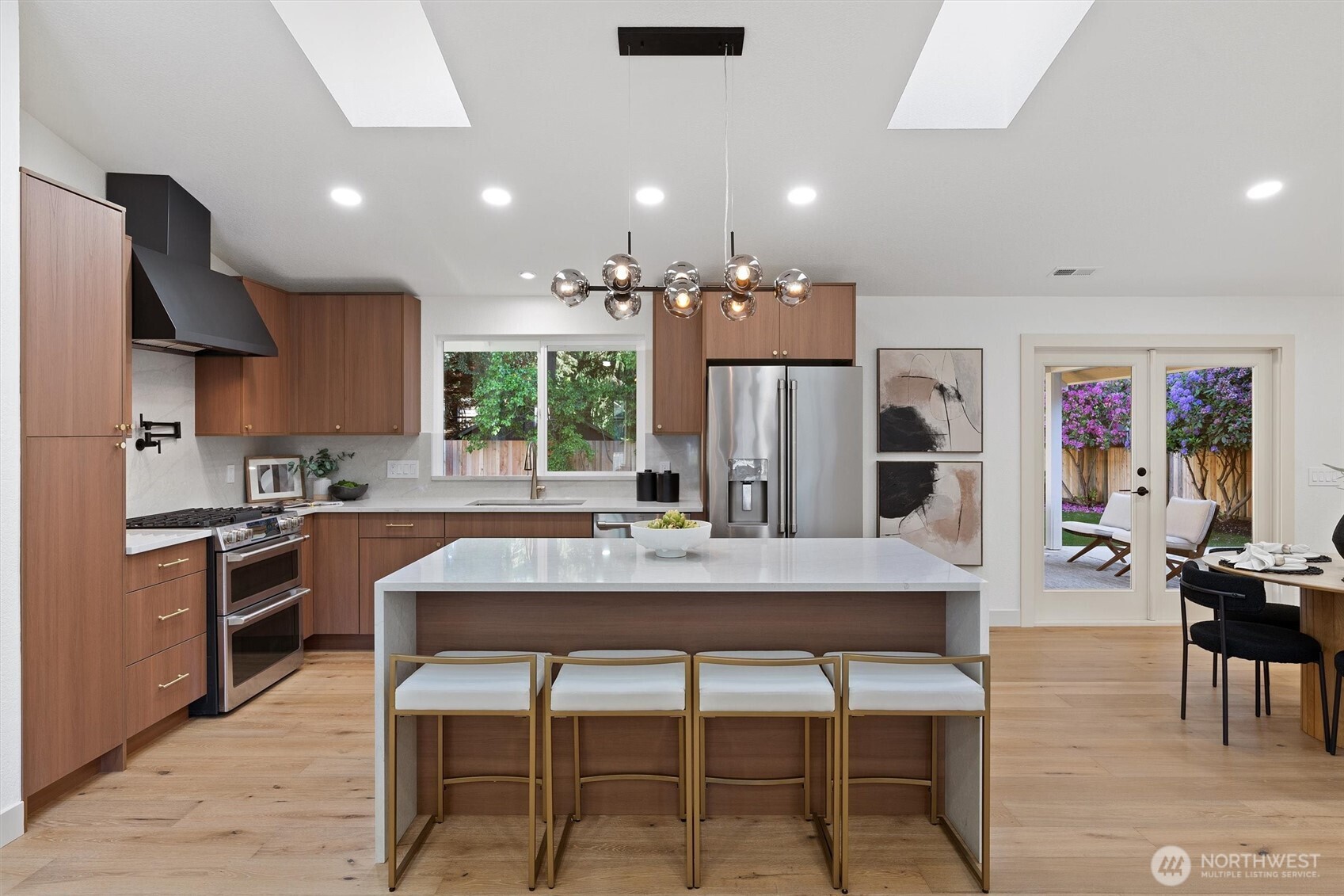 A stunning waterfall island anchors the kitchen with Lumataj quartz and sleek, sculptural lines. The perfect place to connect, cook, and create.