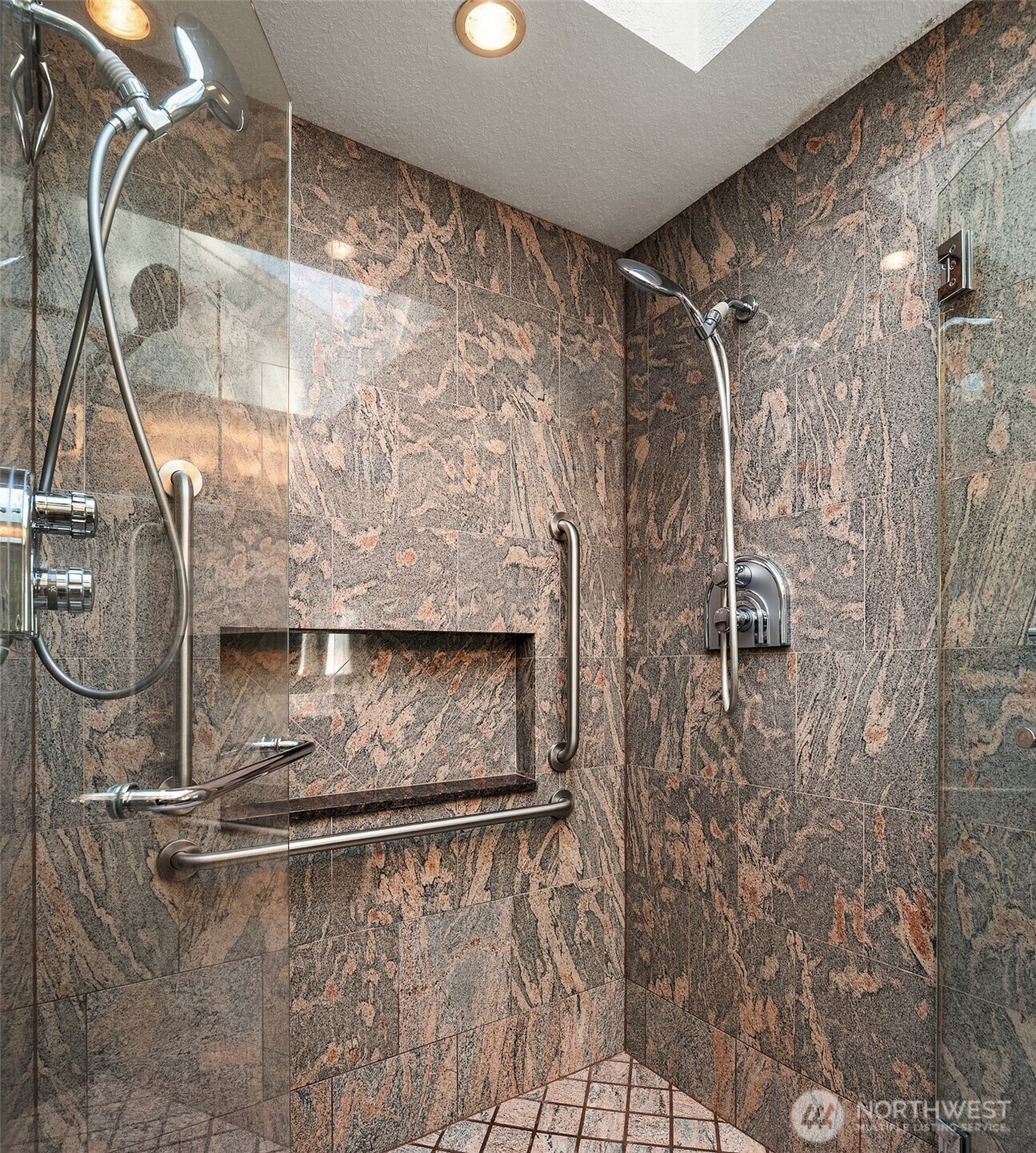 The spacious walk-in shower offers a trendy design, skylight and two showerheads.