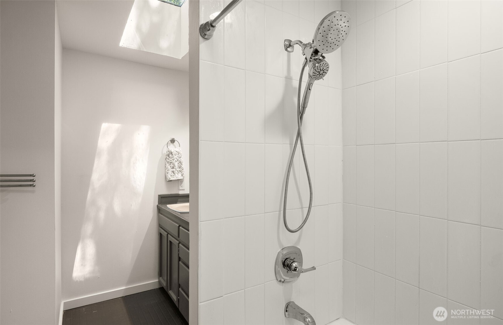 The guest bathroom was just recently refreshed with a new bathtub, fixtures, and a tile surround.