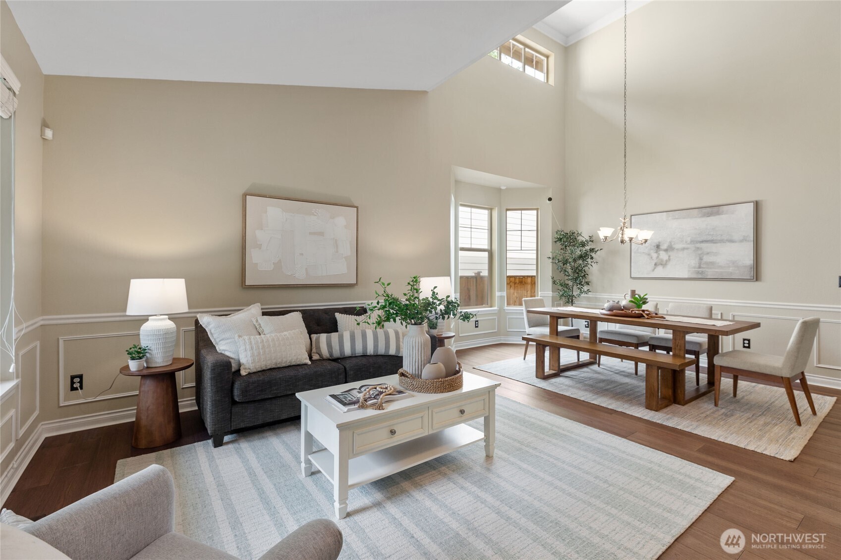 Bright and airy living and dining space with vaulted ceilings, hardwood floors, and elegant finishes. Stylish and inviting with abundant natural light.