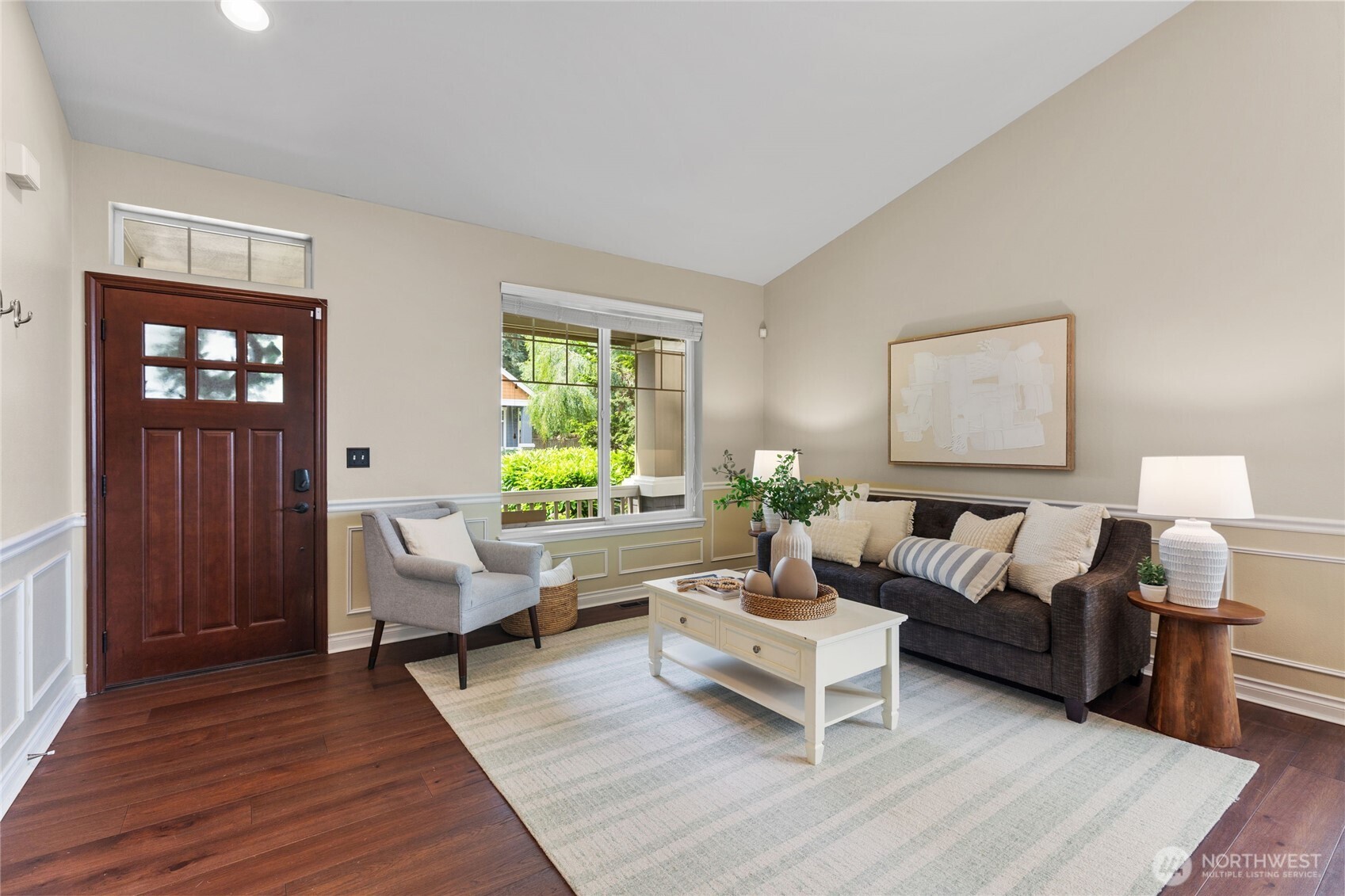 Inviting living room with and large window framing lush greenery. A warm, welcoming entry sets the tone for the rest of the home.