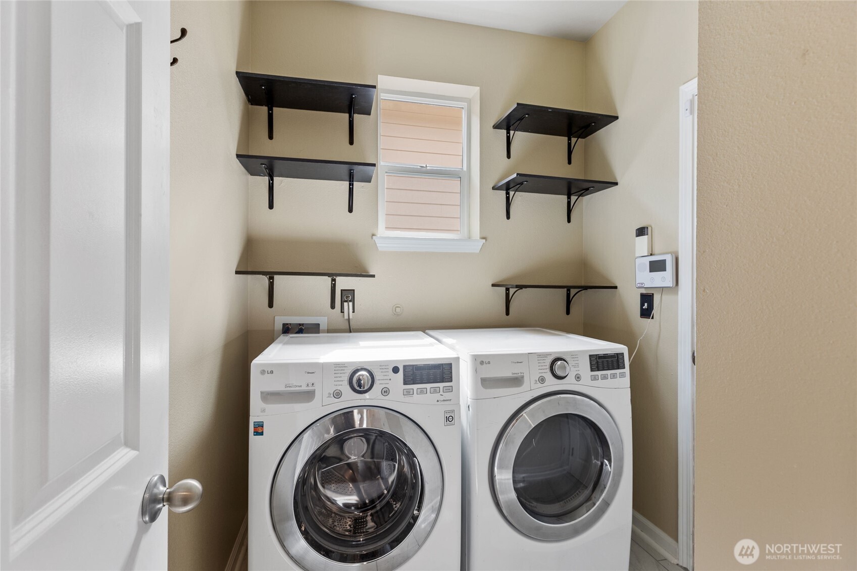 Washer and dryer included with home sit nicely in the tiled mudroom.