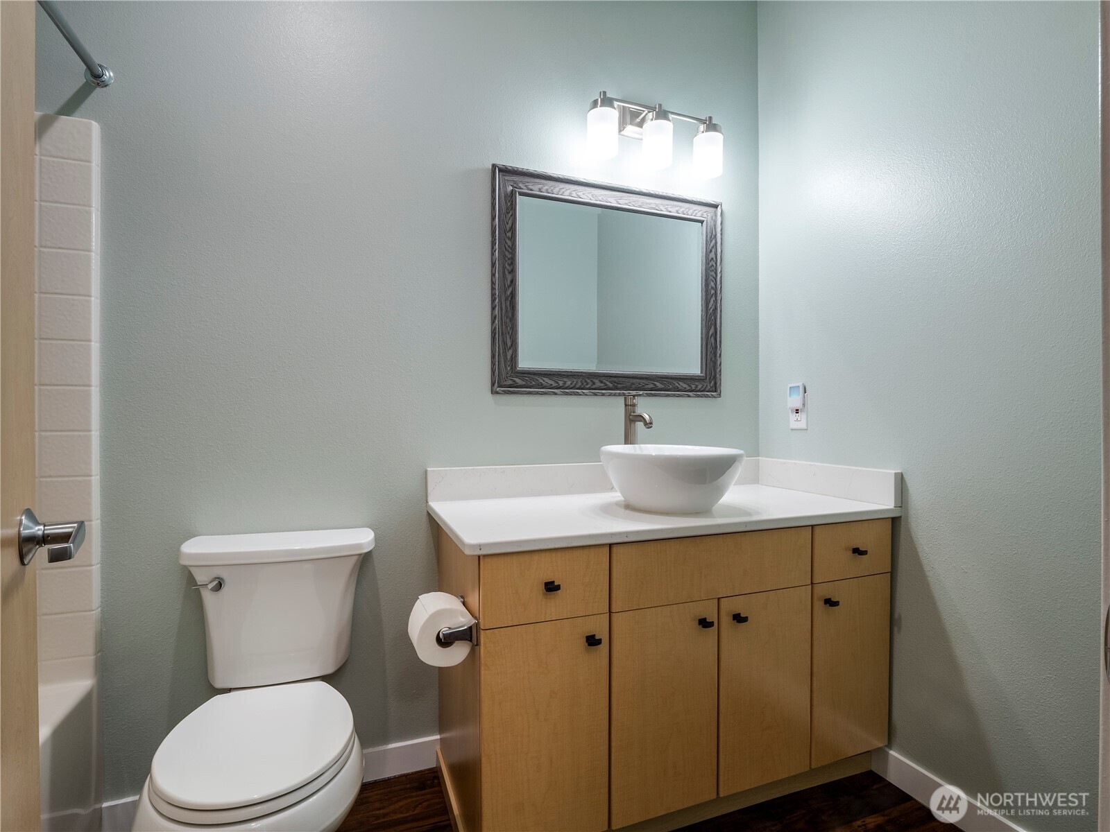 The secondary bedroom feels large with vaulted ceilings and a large window overlooking the lush landscaping. LVP flooring flows from this room into the main hallway, utility space and main bathroom.