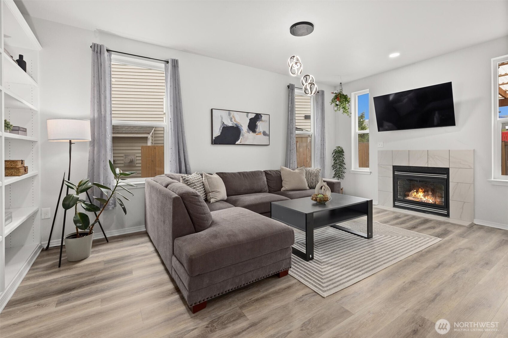 Spacious Family Room with gas fireplace, ample windows, custom built shelving. TV Mount stays (TV does not).