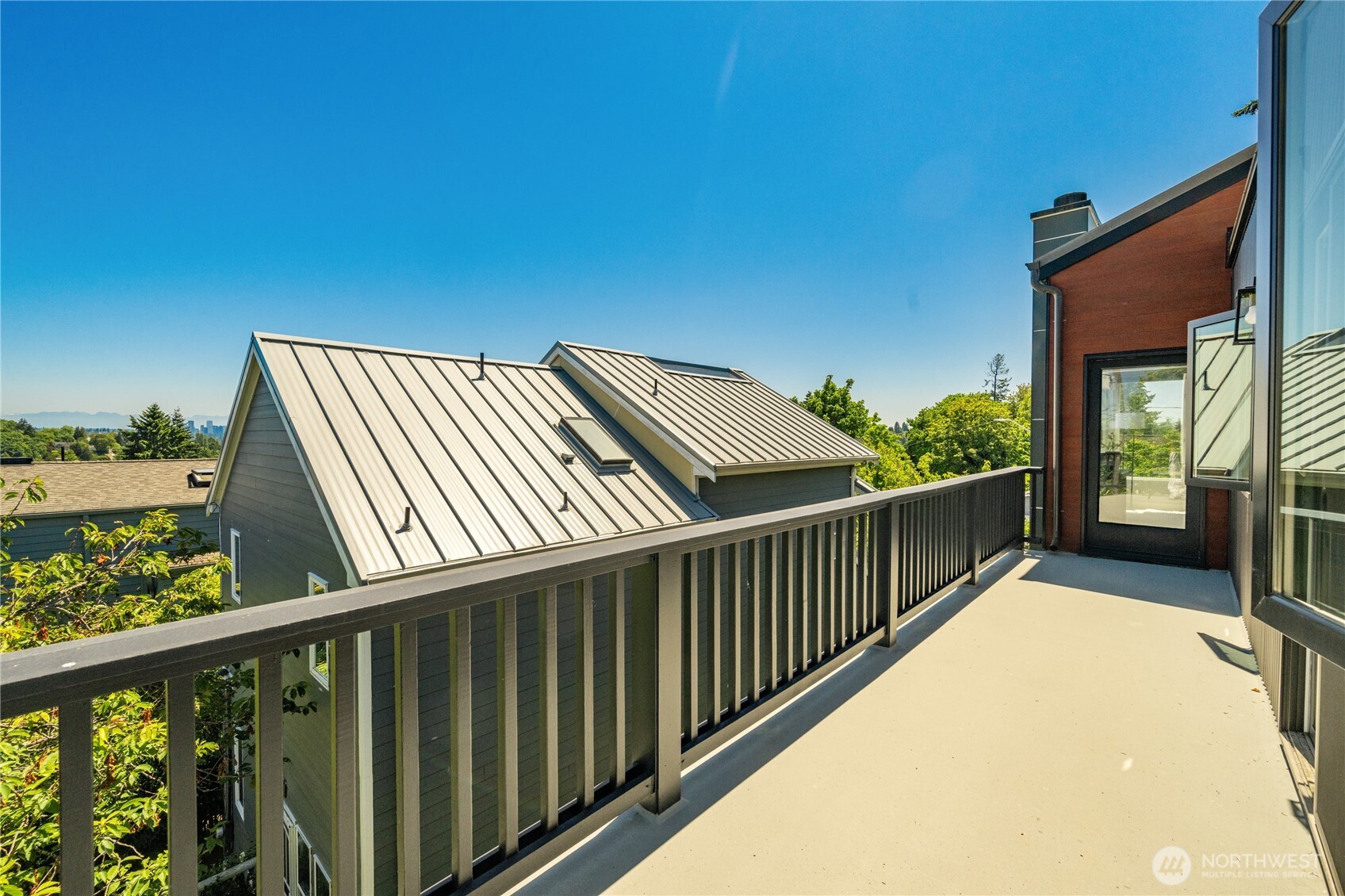 Expansive east facing balcony off the primary runs the entire length of the house and features views of Lake Washington, the Cascades and the Bellevue skyline