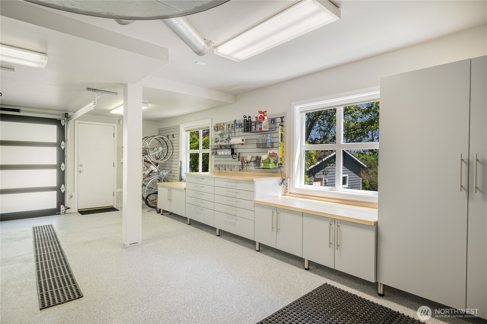 Epic 2-car garage features amazing shop space with workbench, tool storage, wall organizers and large storage closets