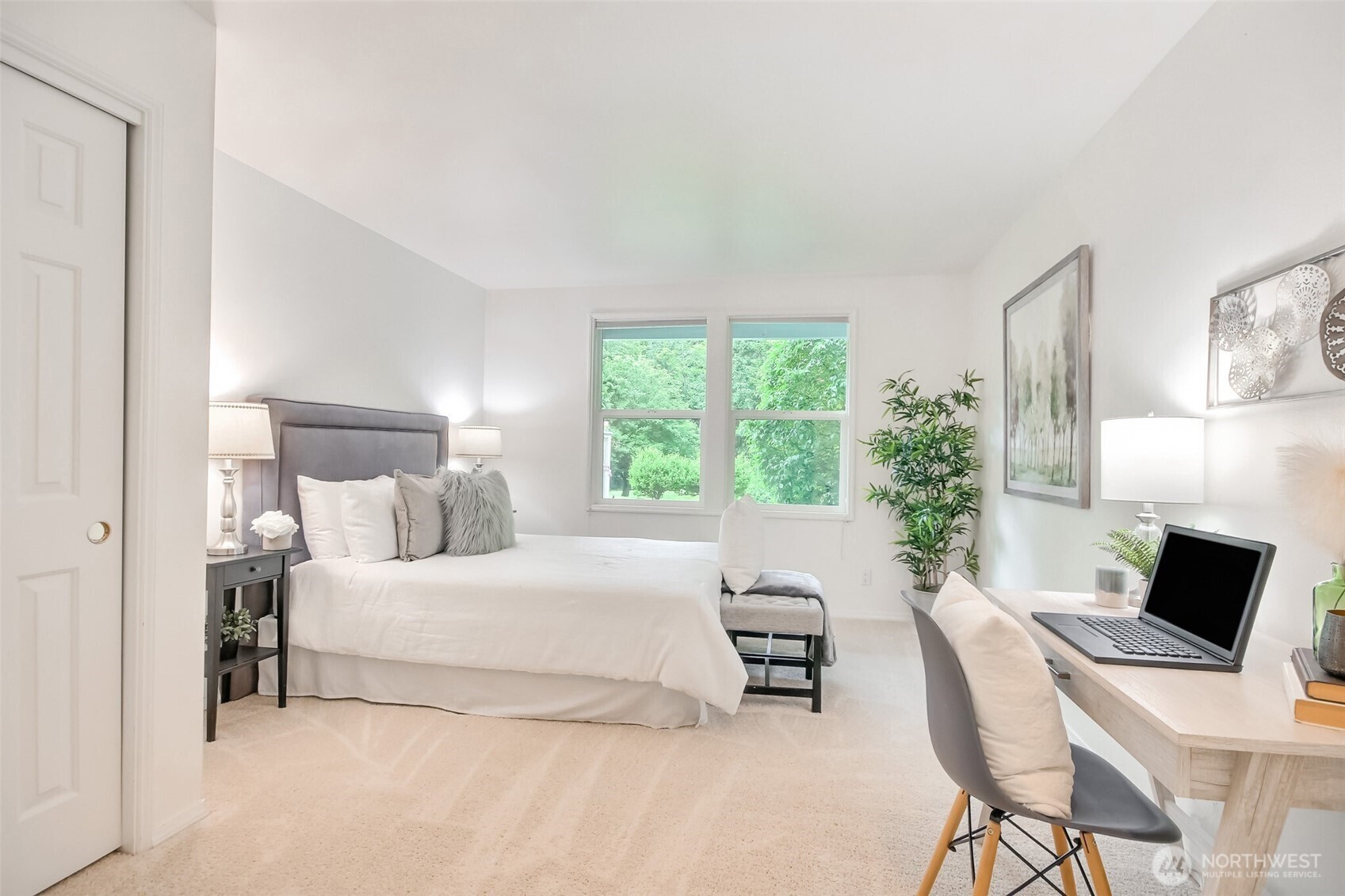Primary bedroom with ample closet space windows that look out to nature and big enough for a king sized bed