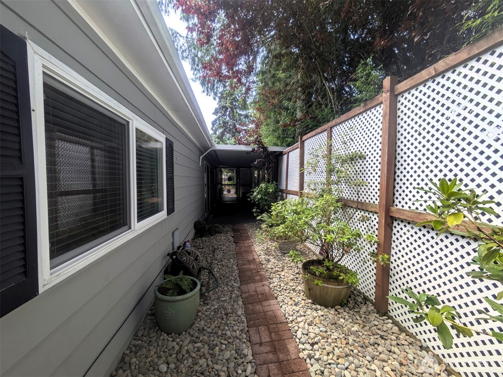 West side of house. Walkway and privacy lattice.