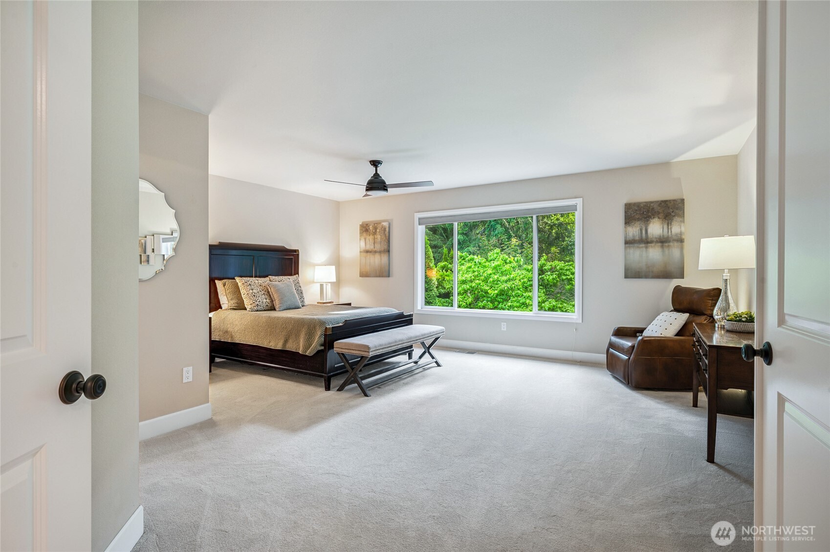 Generously sized primary suite, overlooks the lush greenbelt backdrop.