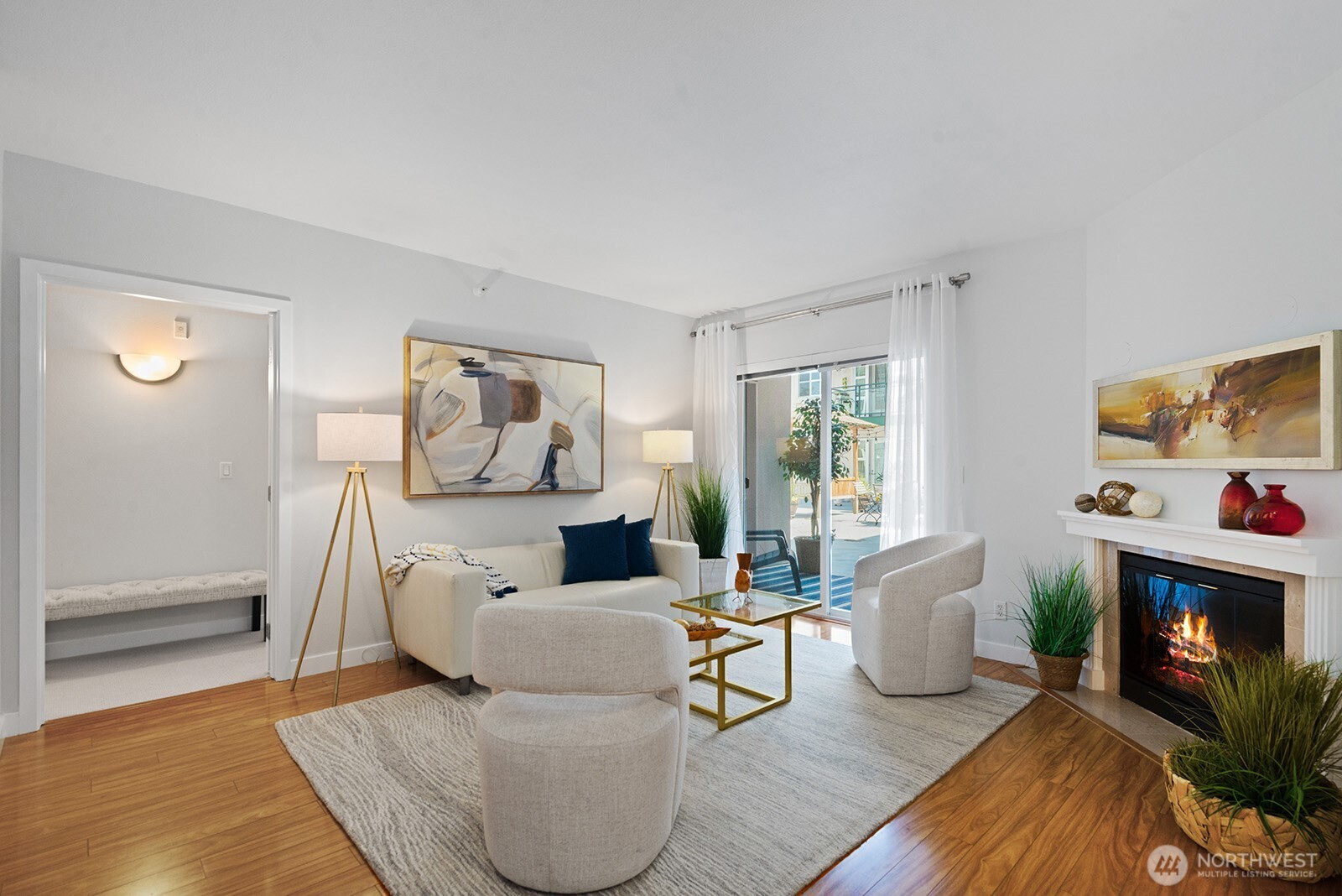 The living room features an electric fireplace. The opening to the left is to the primary bedroom.