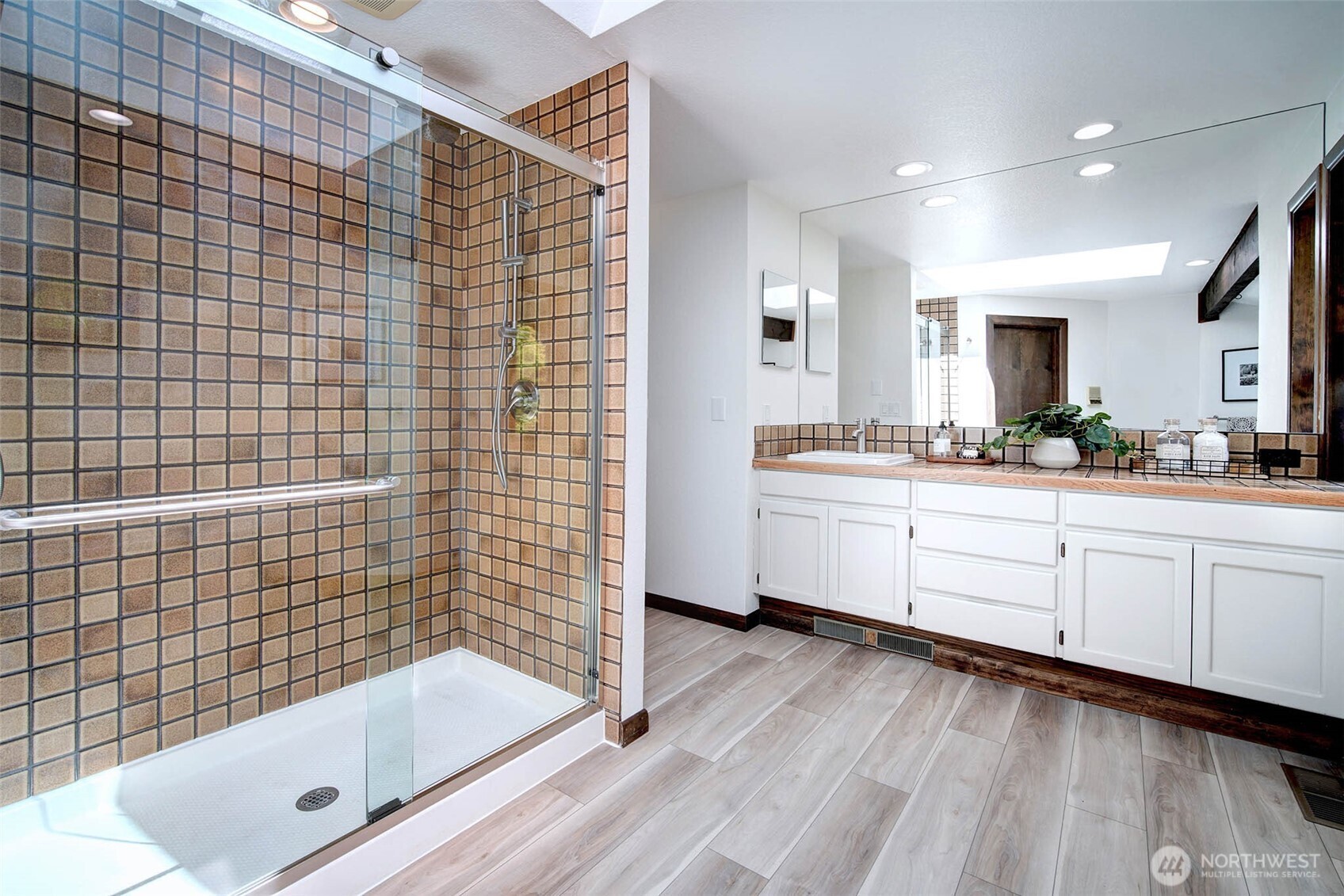 Newly updated Primary Bath features a tiled shower with 2 shower sdheads