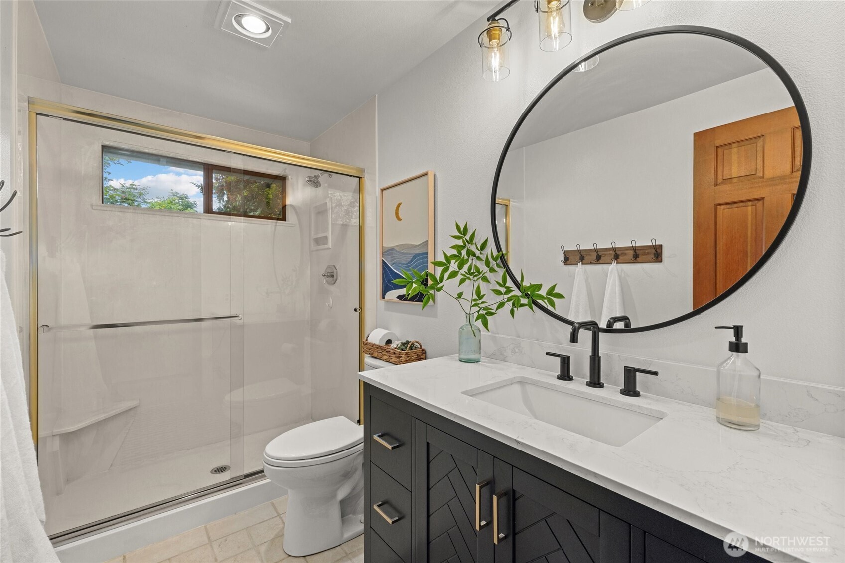 The main bathroom has an oversized shower which works so much better than a bathtub/shower combo. The updated vanity, light fixture and mirror all come together just perfectly!