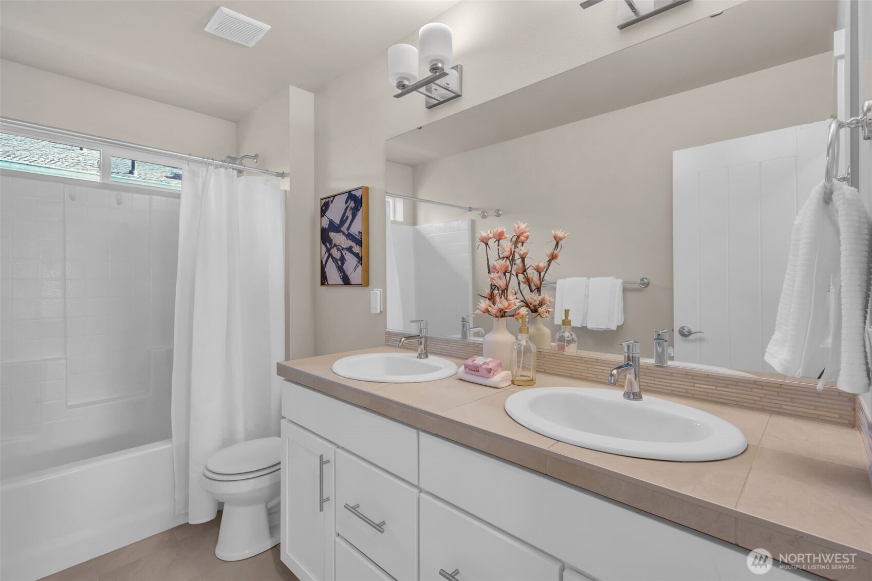 Upstairs bathroom with double sinks and full bath/shower.
