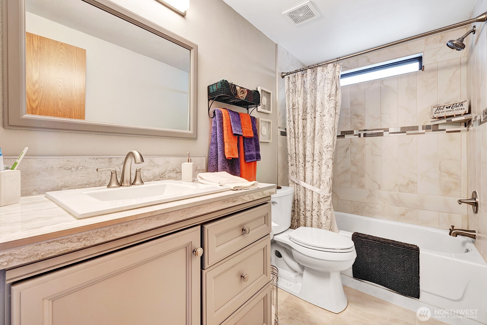 Updated, Full guest bath offers taste full designer accents, tile surround, new vanity with custom storage.