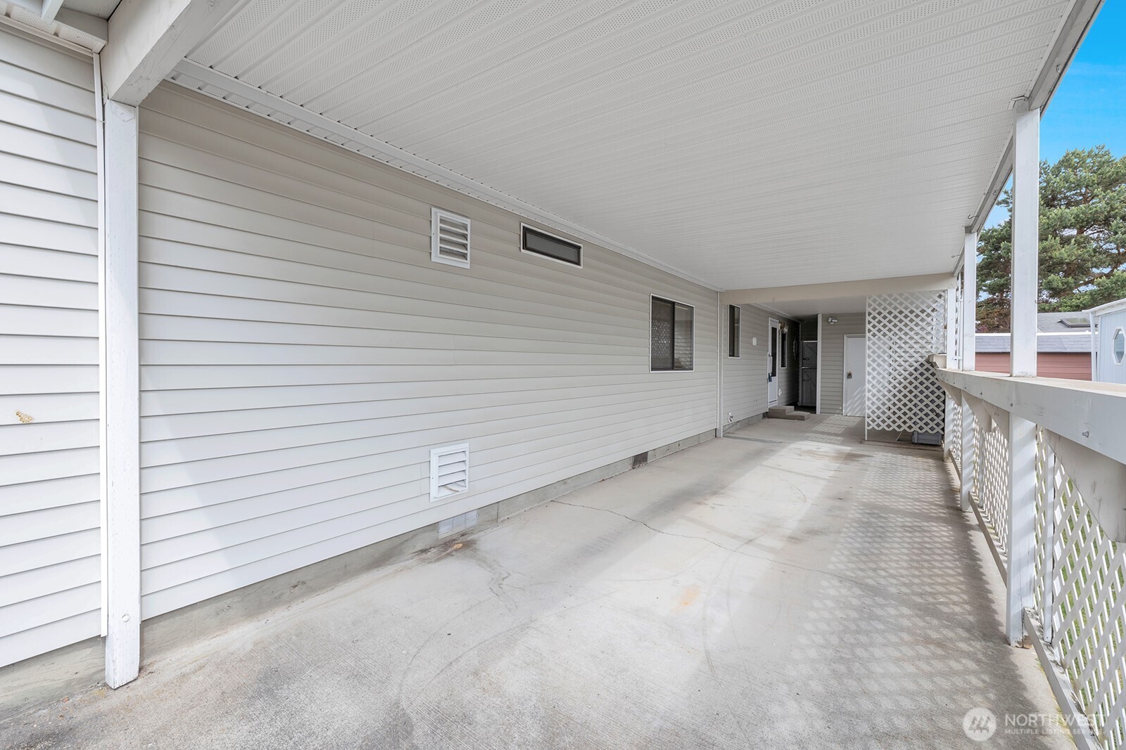 Deep carport will easily accommodate two standard sized vehicles and still have the space behind the 1/2 wall for storage of recycle totes etc.