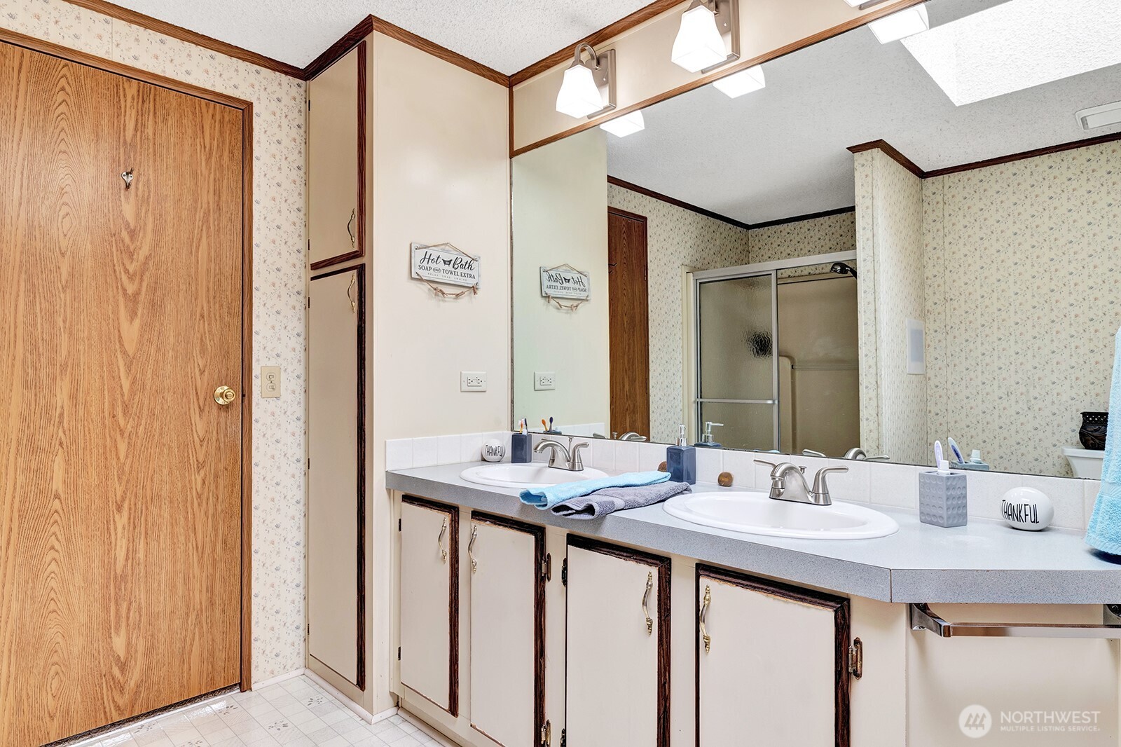 Private, 4-piece primary bath. Tons of storage cabinets and shelves for all personal items and necessities. Open area with easy access for walker or wheelchair.