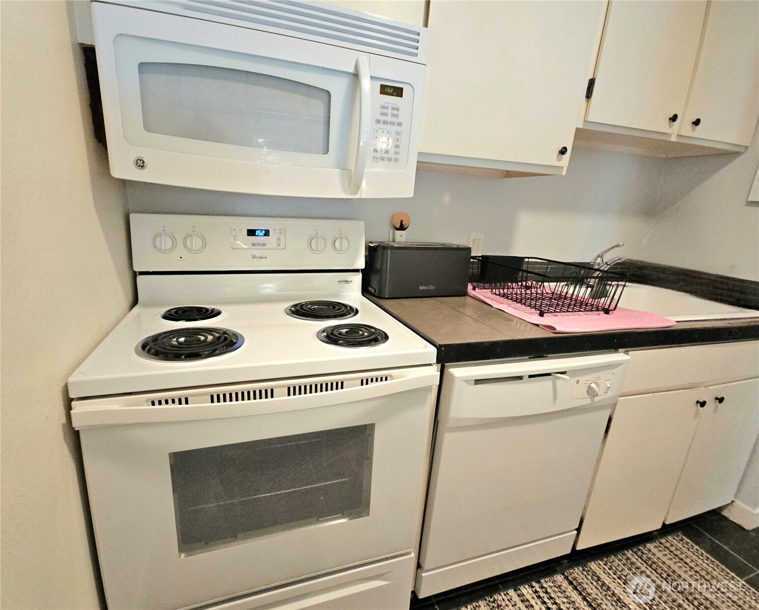 which includes crisp, white appliances and cabinets.