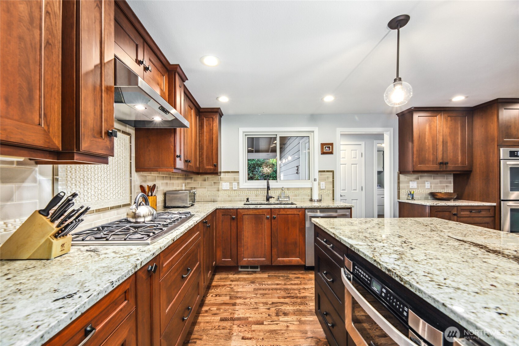 Expansive kitchen with endless storage, granite counters and designer light fixtures.