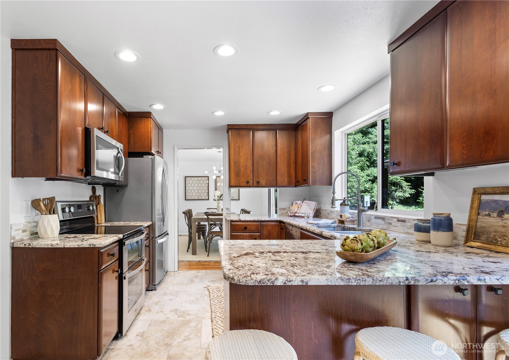Chef’s kitchen with cherry cabinets and marble counters, ideally positioned between the dining room, breakfast nook, and family room for effortless entertaining and daily living.