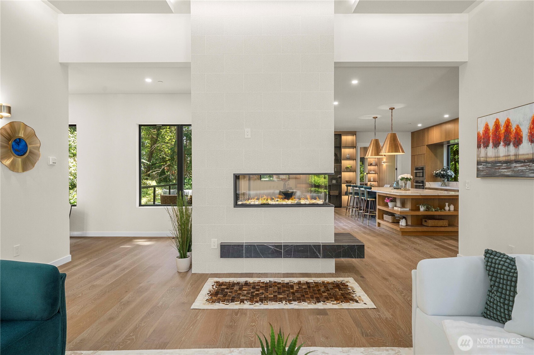 The modern dual-sided fireplace enhances the spacious living area