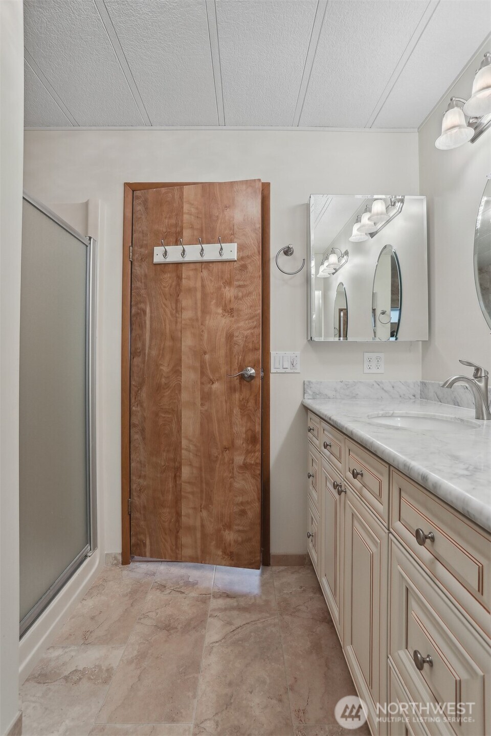 Primary bedroom suite with vaulted ceilings, walk in closet and a fully remodeled tiled 5 piece bathroom.
