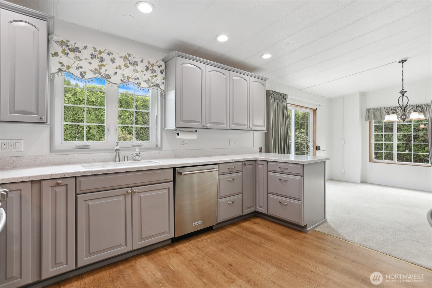 Fully remodeled gourmet kitchen with quartz counters, stainless appliances and a breakfast bar that opens to the dining area and family room with a sliding door to the back patio for indoor/outdoor living.