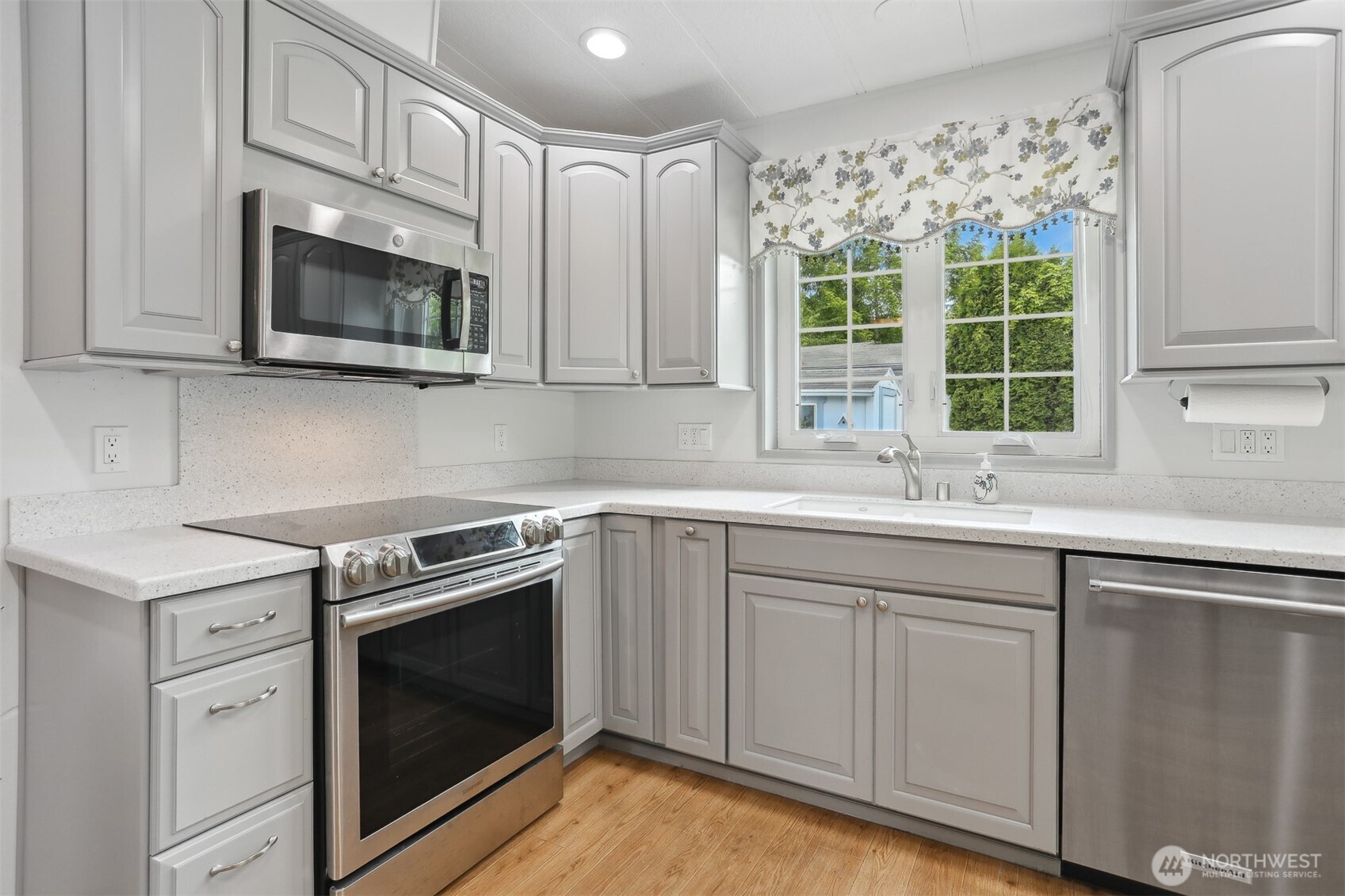 Fully remodeled gourmet kitchen with quartz counters, stainless appliances and a breakfast bar that opens to the dining area and family room with a sliding door to the back patio for indoor/outdoor living.