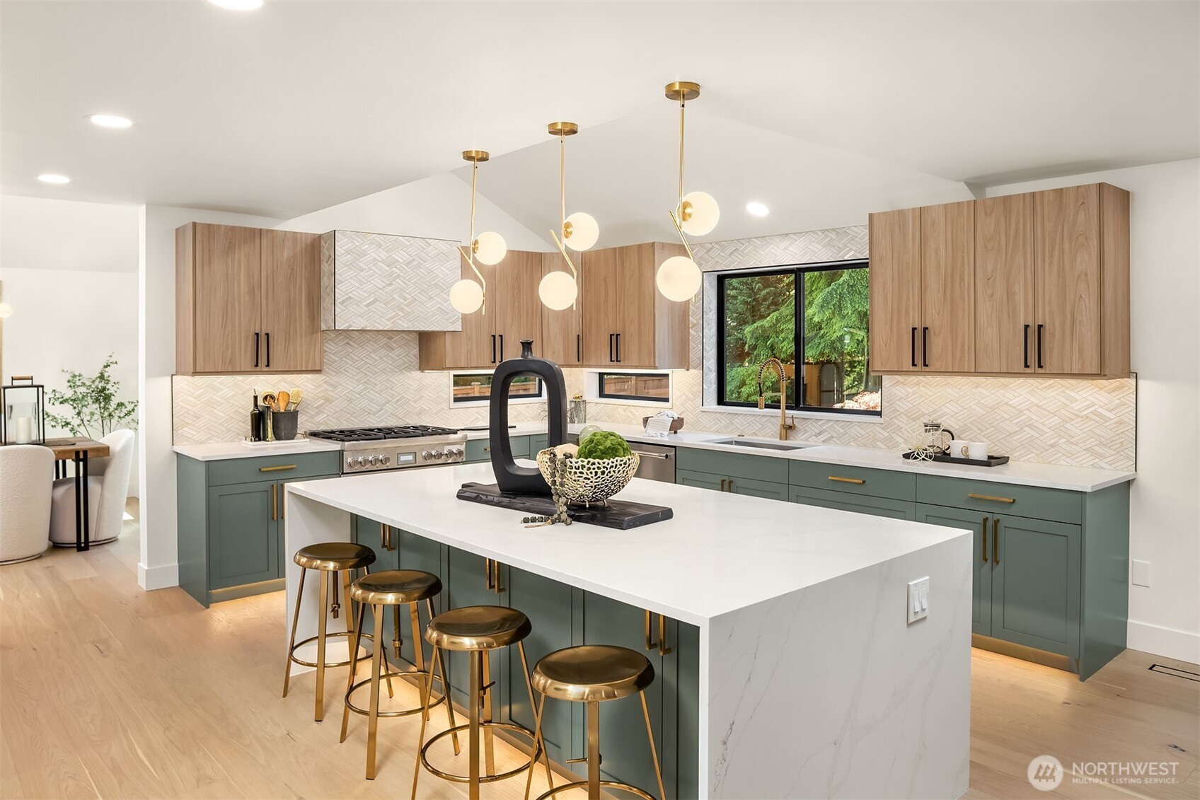 Fully renovated kitchen with oversized waterfall quartz island, quartz countertop, custom tile, Thermador appliance suite and custom cabinetry.