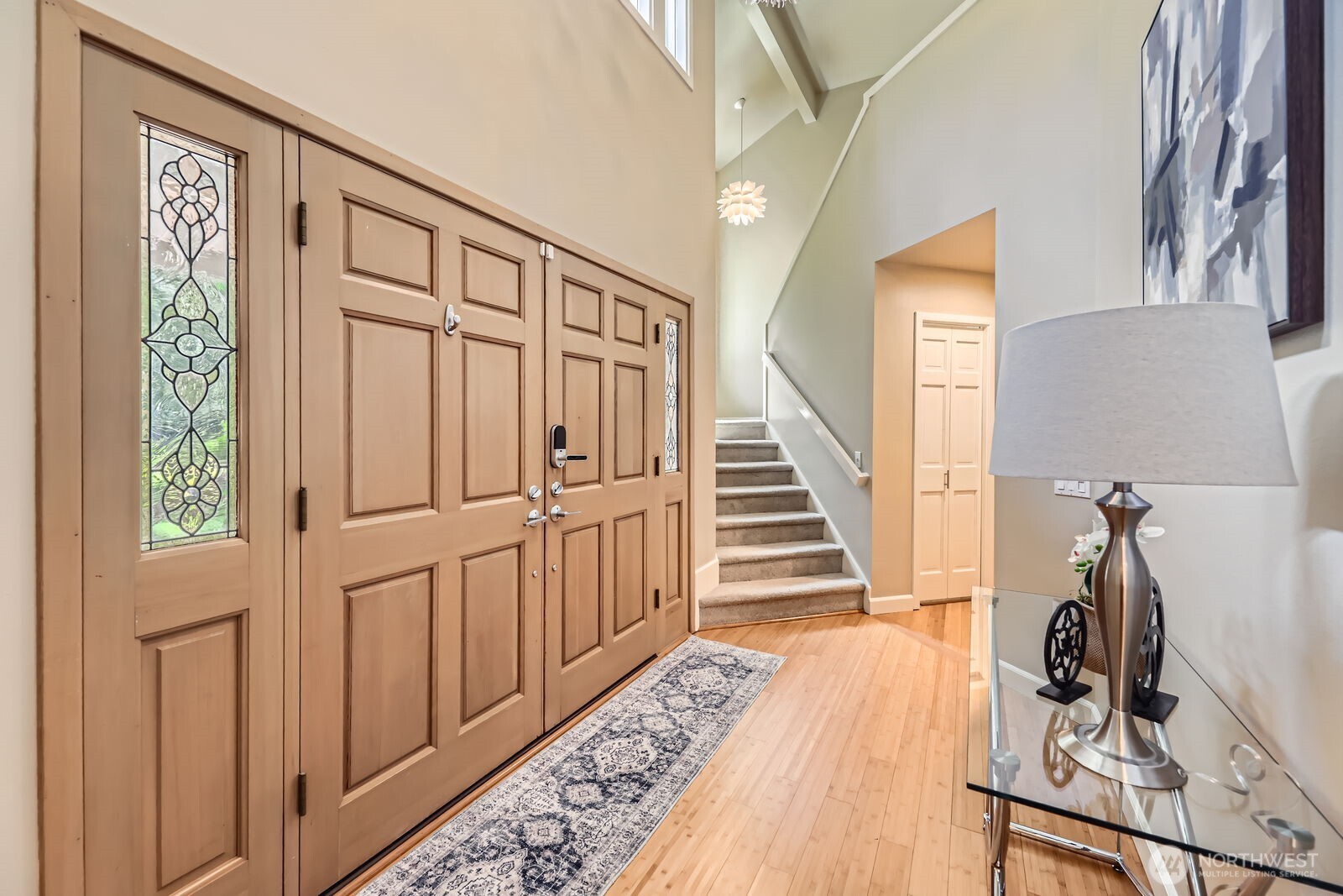 Double doors open to a Soaring entry with custom lighting.