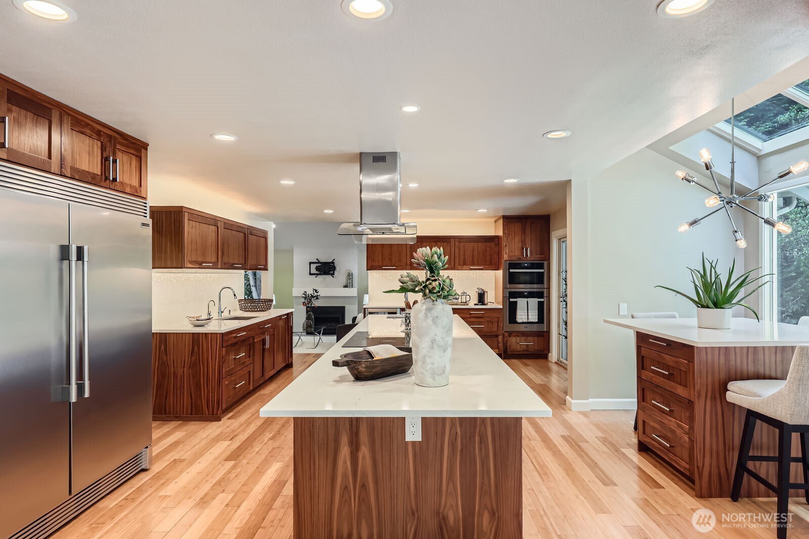 A large island with eating bar and a built-in walnut café table with a skywall window adds to the appeal of this kitchen.