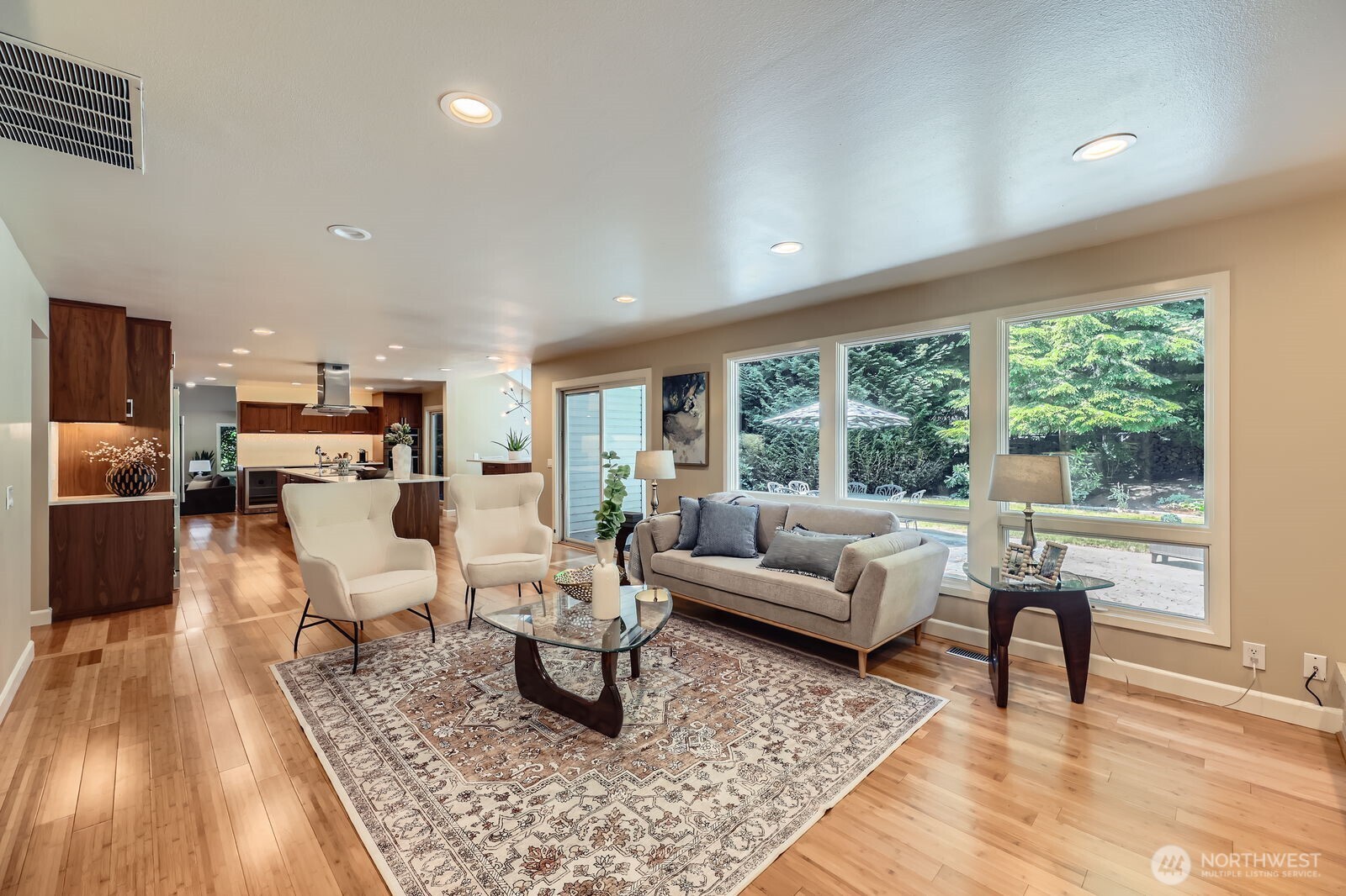 A wall of windows in the family room frames the lush backyard view.