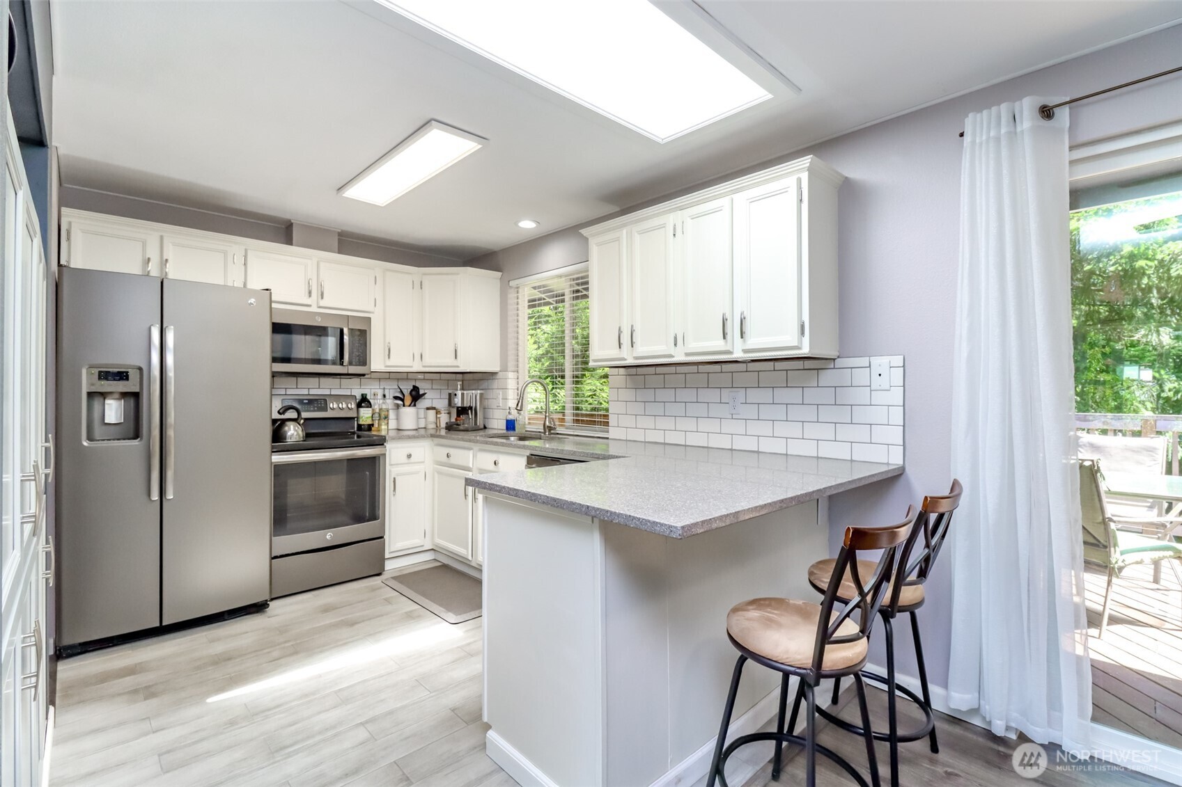 Bright and open kitchen, with bar seating.