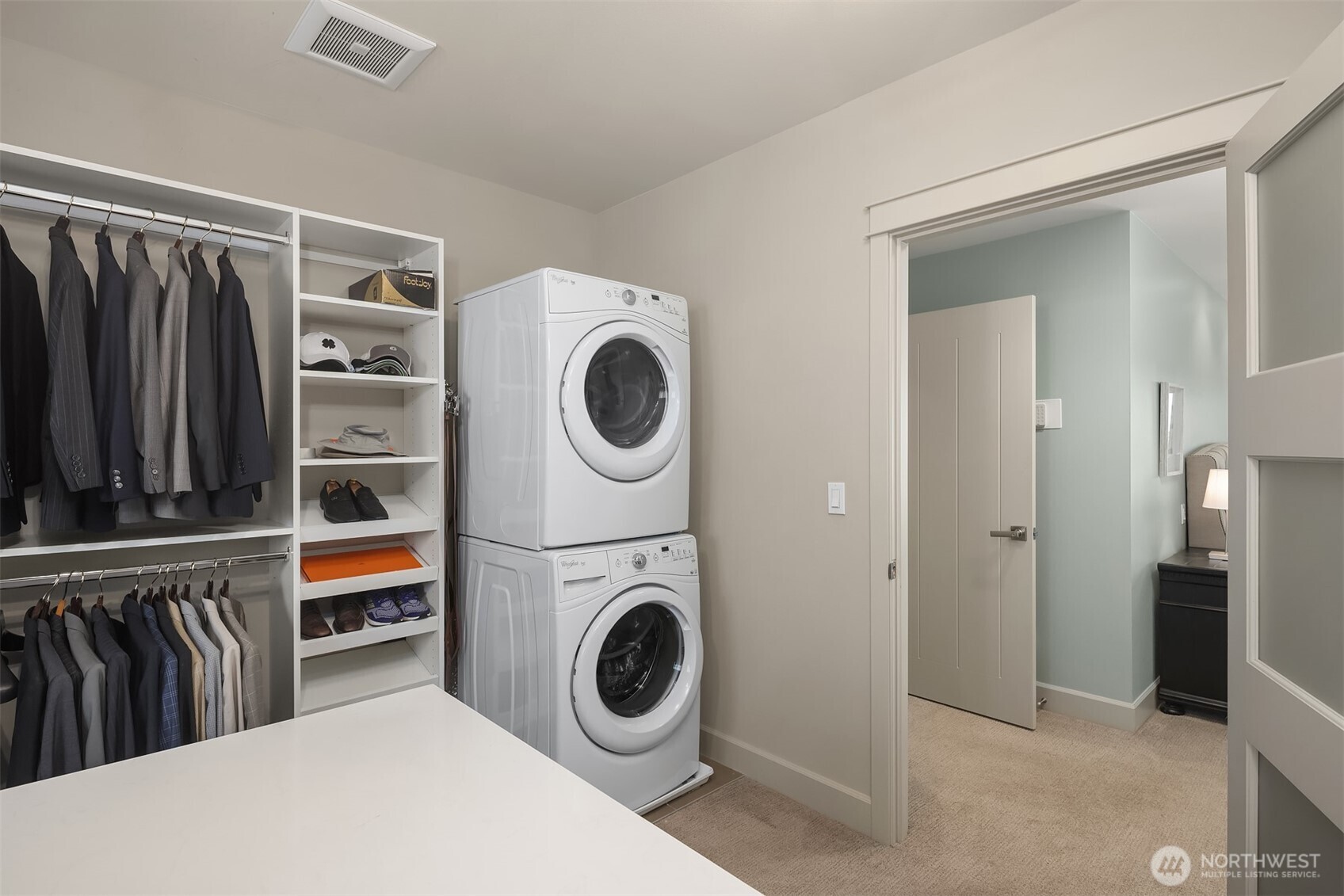 Spacious primary closet with dedicated washer and dryer.