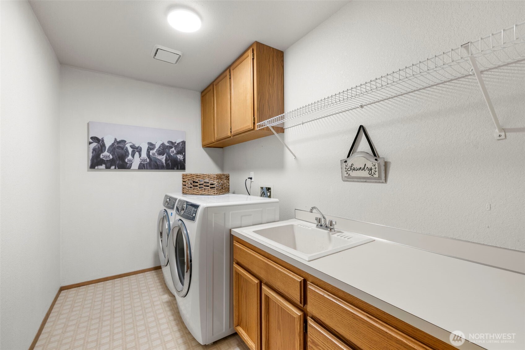 Laundry room with storage cabinets and counter top and utility sink.