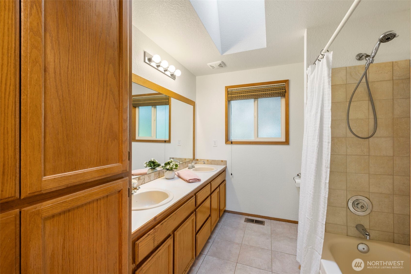 Main guest bath with tile floors and tub surround.