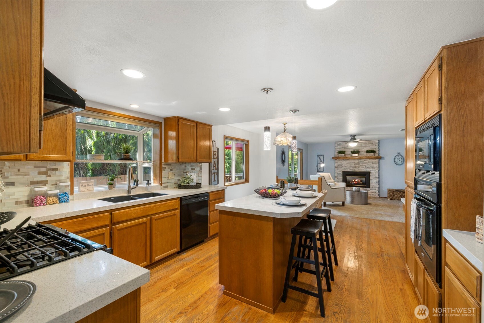 Oak cabinets and hardwood floors. Quartz counter tops and tile backsplash. Gas cooking, two ovens and built in microwave.