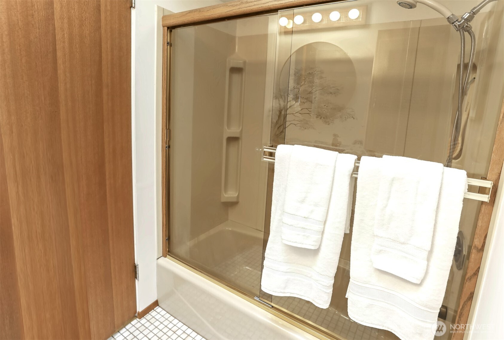 Shower/tub combo in full bathroom.
